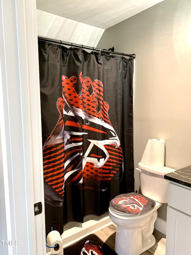 bathroom with toilet, hardwood / wood-style floors, a shower with shower curtain, vaulted ceiling, and vanity