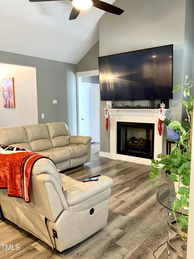 living room with lofted ceiling, hardwood / wood-style floors, and ceiling fan