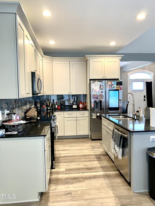 kitchen featuring white cabinets, appliances with stainless steel finishes, light hardwood / wood-style flooring, and sink