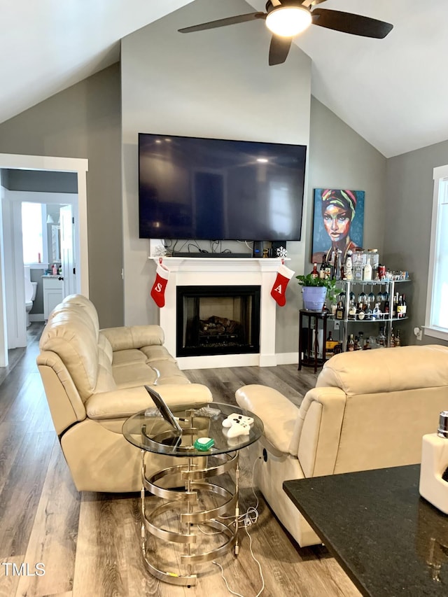 living room featuring lofted ceiling, wood-type flooring, and ceiling fan