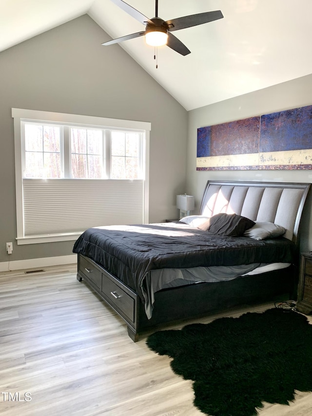 bedroom featuring ceiling fan, light wood-type flooring, and lofted ceiling