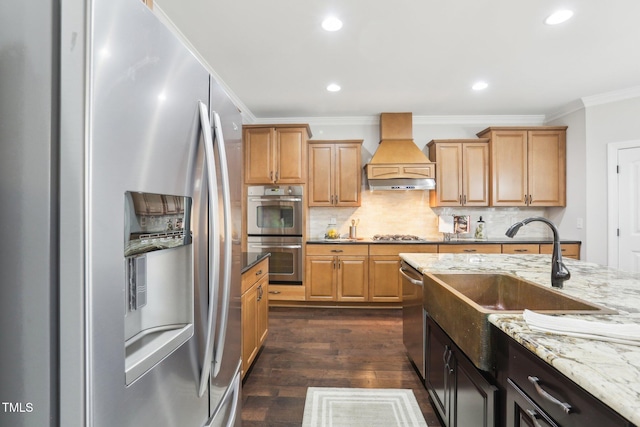 kitchen featuring light stone countertops, premium range hood, dark wood-style flooring, appliances with stainless steel finishes, and crown molding