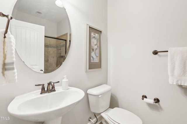 full bathroom featuring toilet, a tile shower, and a sink