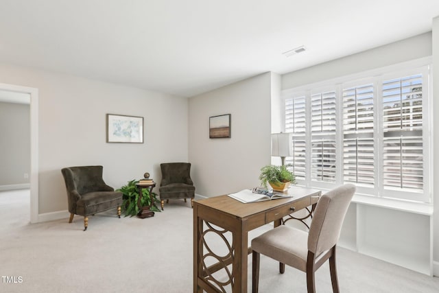 office area featuring visible vents, light colored carpet, and baseboards