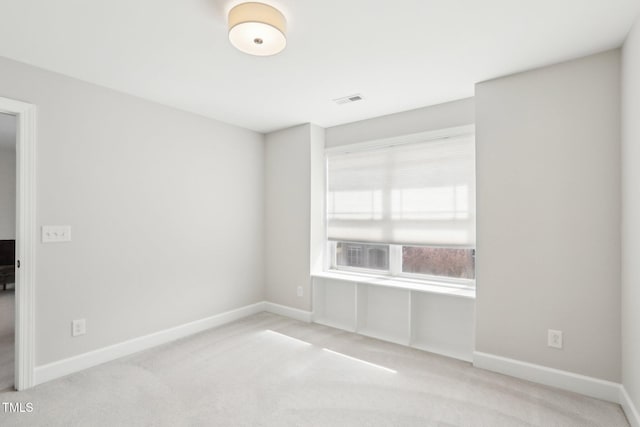 carpeted spare room with baseboards and visible vents