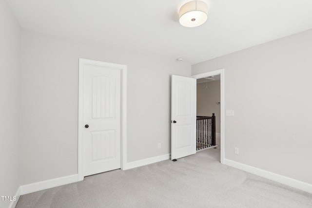 unfurnished bedroom with baseboards and carpet