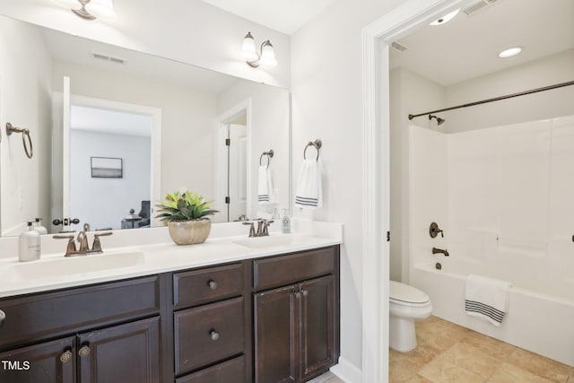 bathroom with double vanity, toilet, visible vents, and a sink