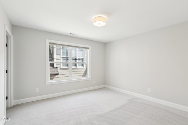 carpeted empty room featuring baseboards and visible vents