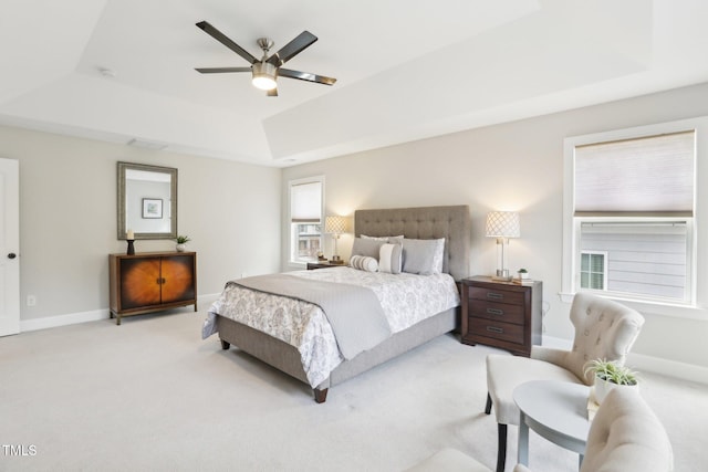 bedroom with ceiling fan, a raised ceiling, baseboards, and carpet floors