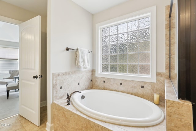 bathroom with a garden tub and tile patterned flooring