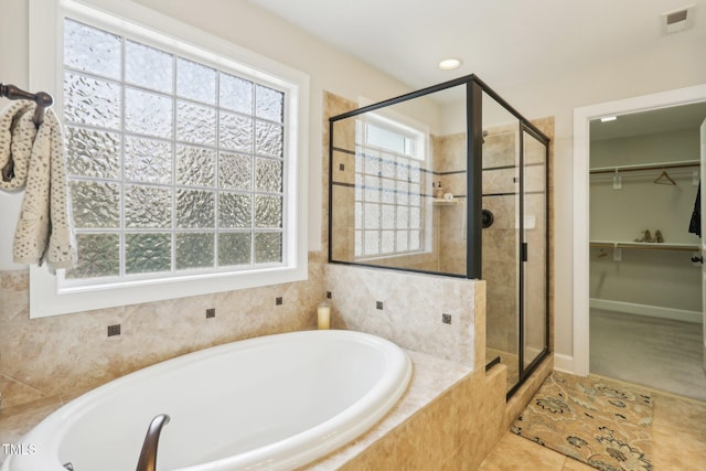 full bathroom with a wealth of natural light, visible vents, a bath, and a shower stall