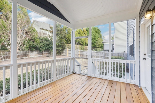 unfurnished sunroom featuring vaulted ceiling