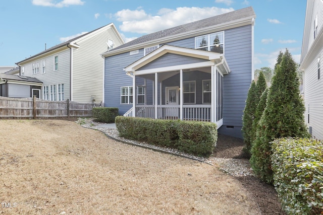 back of house featuring fence, a sunroom, and crawl space