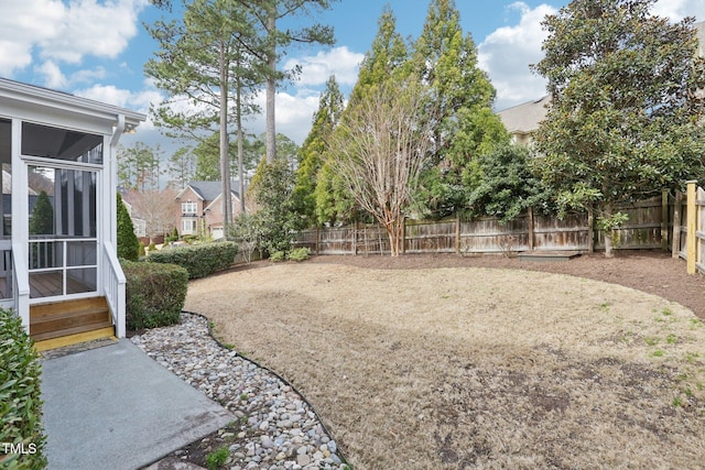 view of yard with a patio area, a fenced backyard, and a sunroom