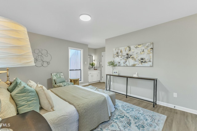 bedroom with connected bathroom and wood-type flooring