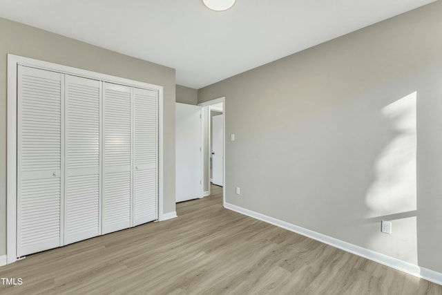 unfurnished bedroom featuring light hardwood / wood-style flooring and a closet