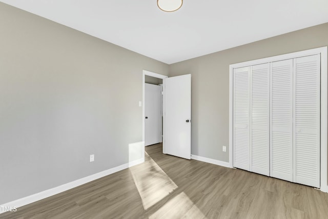 unfurnished bedroom with a closet and light hardwood / wood-style flooring