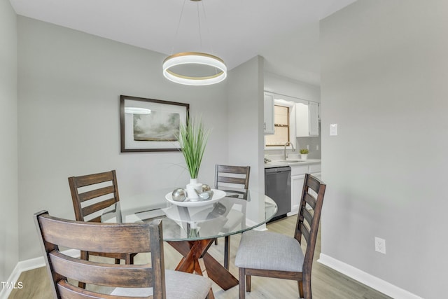 dining area with sink and light hardwood / wood-style flooring