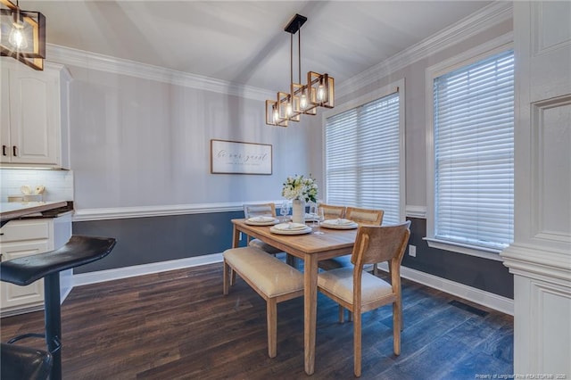 dining area with dark hardwood / wood-style flooring and crown molding