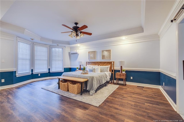 bedroom with ceiling fan, dark hardwood / wood-style flooring, ornamental molding, and a tray ceiling