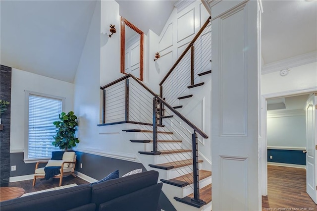 staircase with high vaulted ceiling and hardwood / wood-style flooring