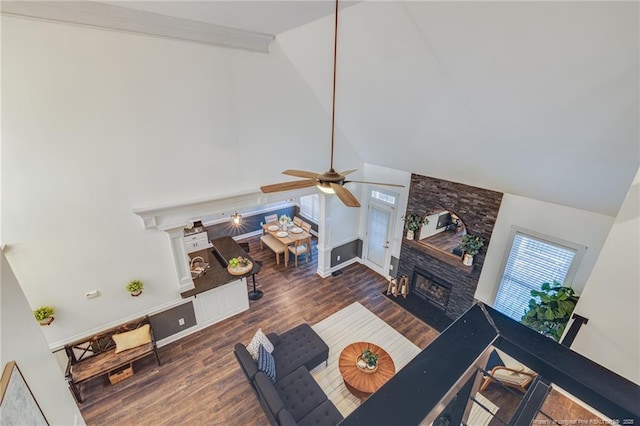 living room with ceiling fan, dark hardwood / wood-style flooring, vaulted ceiling, and a fireplace