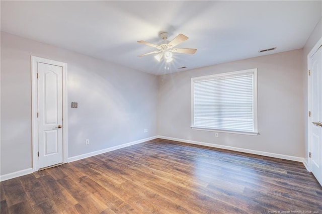 spare room with dark hardwood / wood-style flooring and ceiling fan