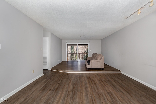 unfurnished room featuring a textured ceiling and dark hardwood / wood-style floors