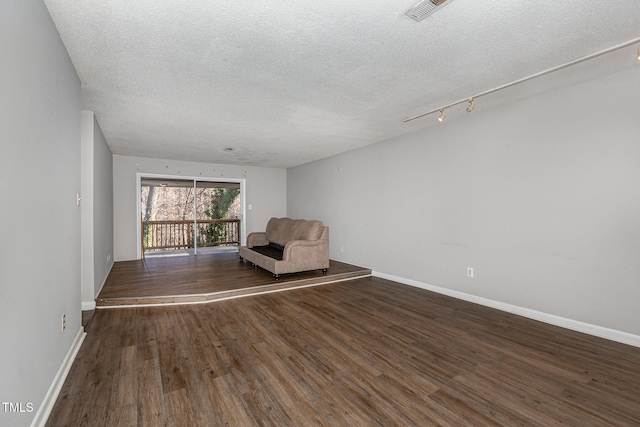 unfurnished room featuring a textured ceiling and dark wood-type flooring