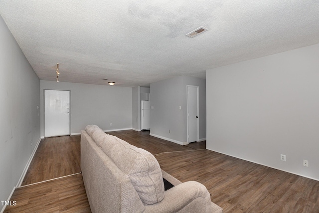 living room featuring dark hardwood / wood-style flooring and a textured ceiling