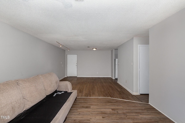 living room with a textured ceiling, dark wood-type flooring, and track lighting