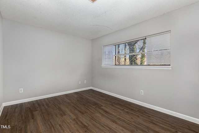 unfurnished room with a textured ceiling and dark hardwood / wood-style floors