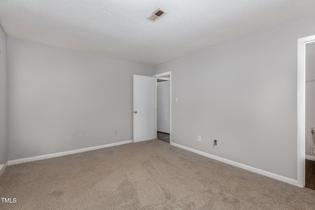 empty room with a textured ceiling and carpet