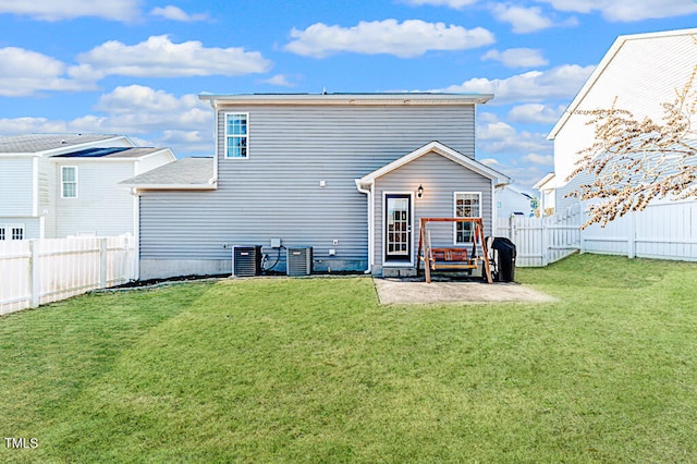 rear view of house with cooling unit, a yard, and a patio