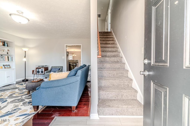 staircase featuring built in shelves and a textured ceiling