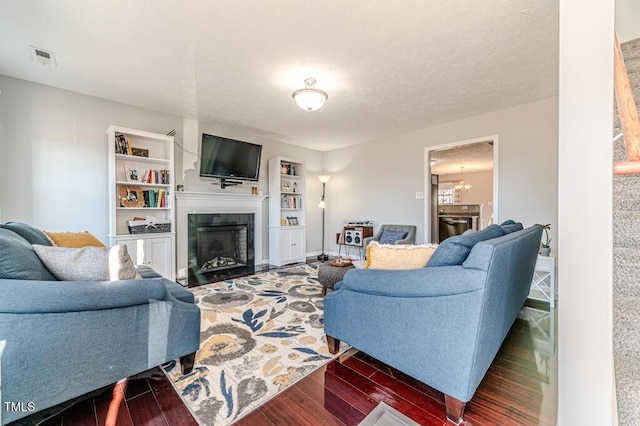 living room featuring dark wood-type flooring and a textured ceiling