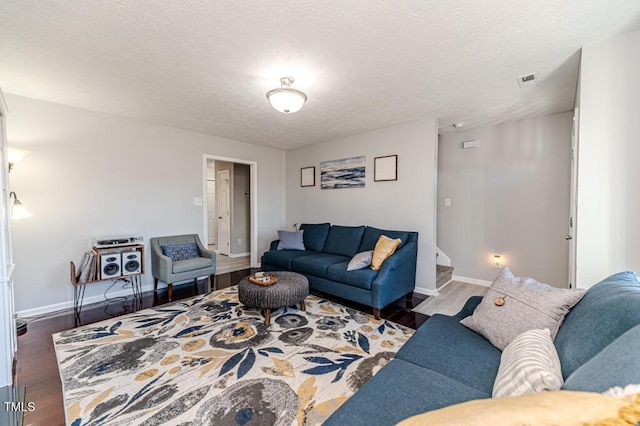 living room featuring a textured ceiling and dark hardwood / wood-style flooring