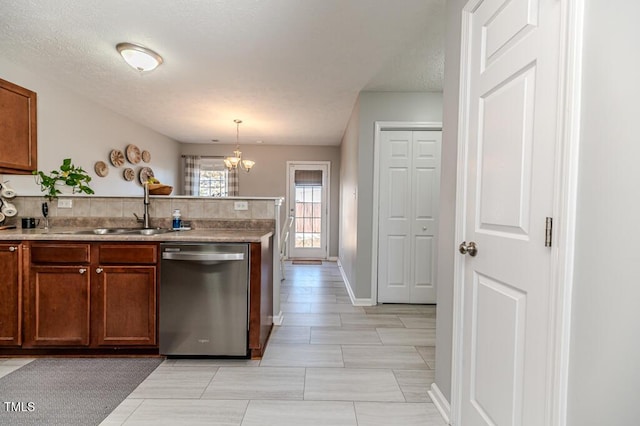 kitchen featuring decorative light fixtures, a notable chandelier, stainless steel dishwasher, sink, and light tile patterned floors