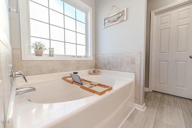 bathroom featuring a tub to relax in and a wealth of natural light