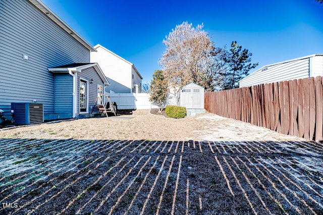 view of yard with central AC and a storage shed