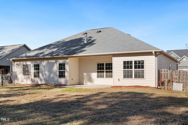 rear view of house featuring a lawn and a patio