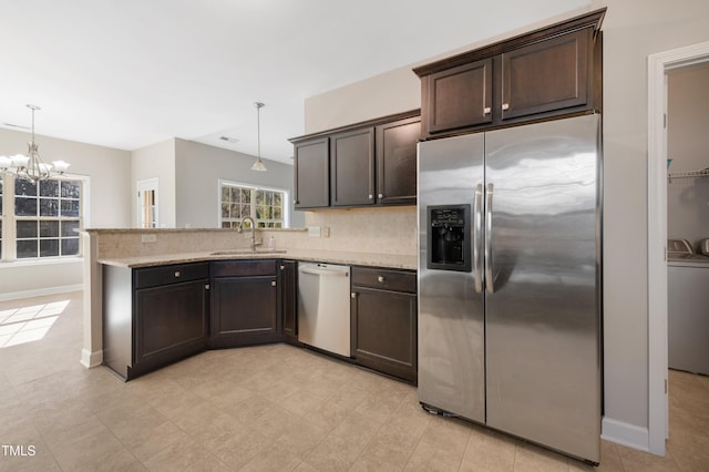 kitchen featuring hanging light fixtures, stainless steel appliances, a notable chandelier, dark brown cabinets, and sink