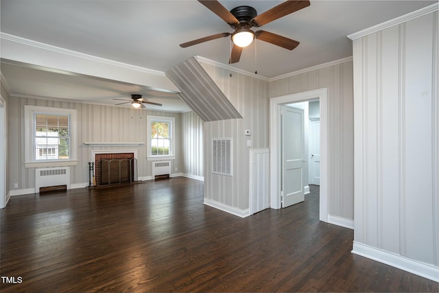 unfurnished living room with a healthy amount of sunlight, dark wood finished floors, visible vents, and radiator heating unit