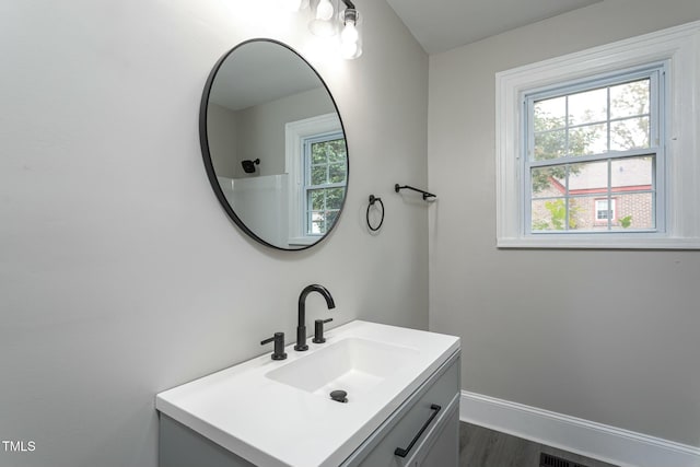 bathroom with baseboards, wood finished floors, and vanity