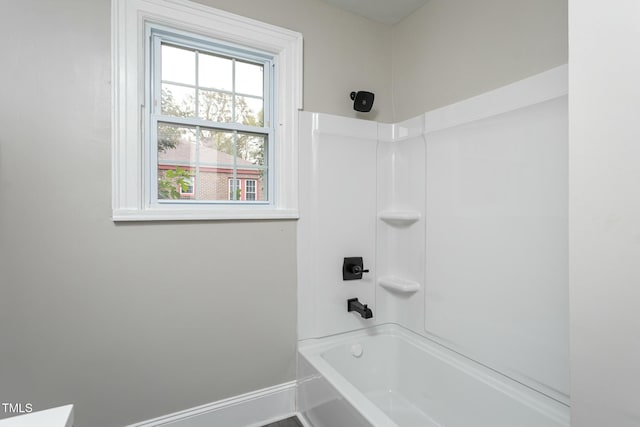 full bathroom featuring bathtub / shower combination and baseboards