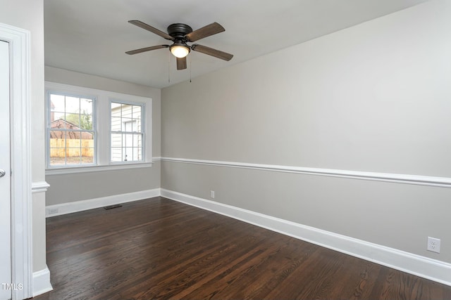 unfurnished room featuring dark wood-type flooring, visible vents, baseboards, and a ceiling fan