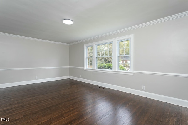 empty room with crown molding, visible vents, baseboards, and dark wood-style flooring