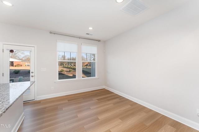 unfurnished dining area featuring light wood-type flooring