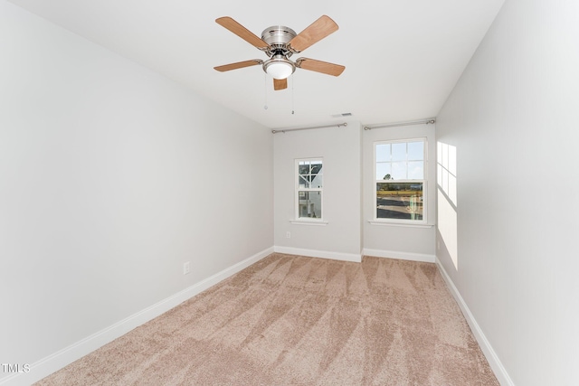 spare room featuring light colored carpet and ceiling fan