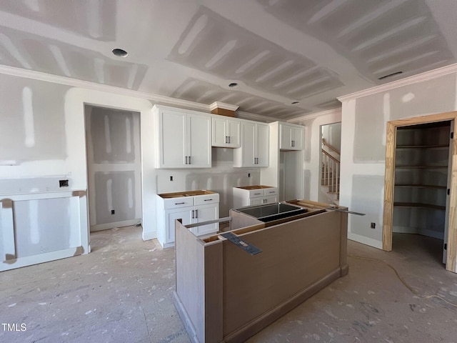 kitchen featuring white cabinets, ornamental molding, and a kitchen island